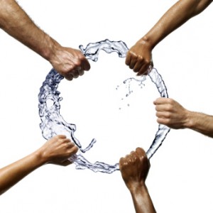 Multiethnic hands holding a suspended ring of water